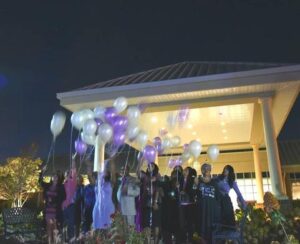 A group of people standing around with balloons.