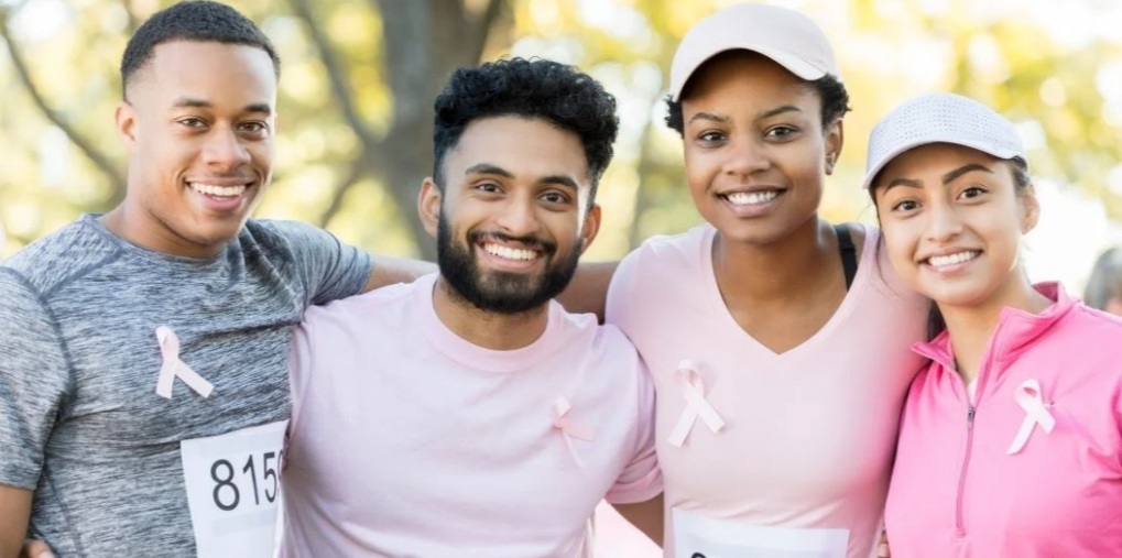 A man and woman in pink shirts posing for the camera.